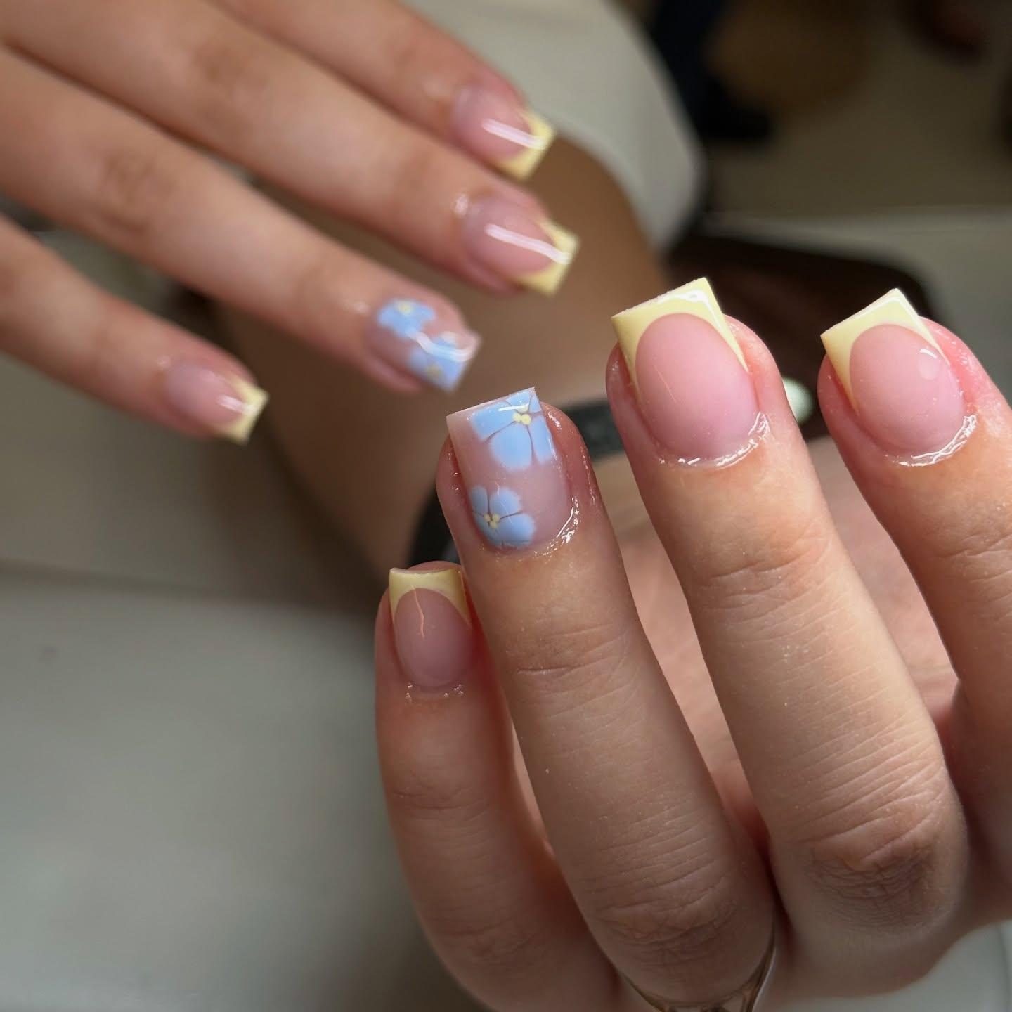 Yellow French tip nails with blue floral nail art at Nel's Nails Portsmouth